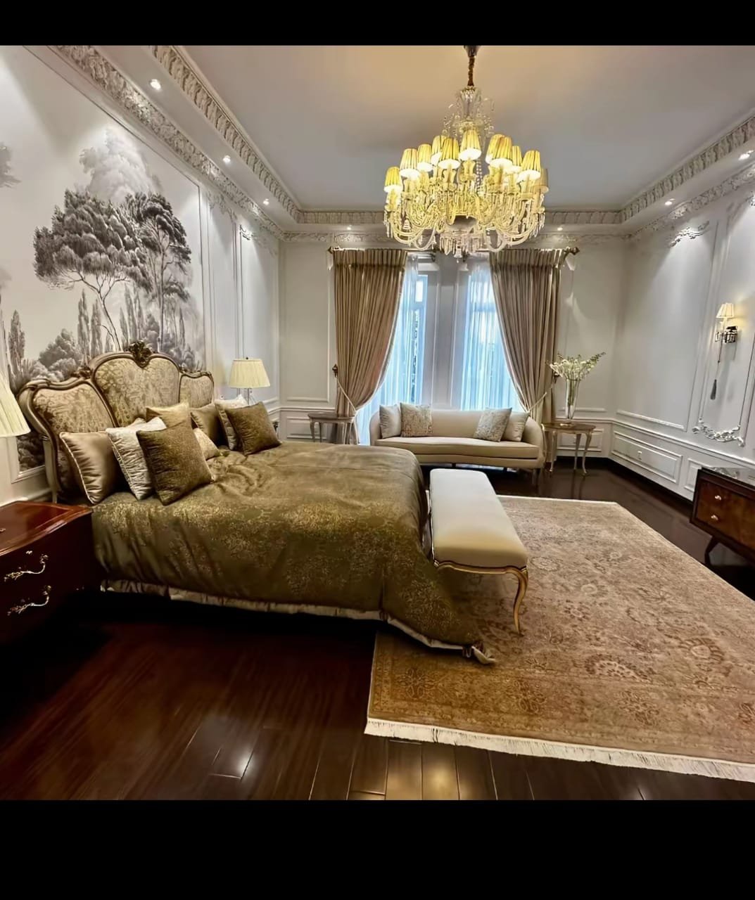 A completed classic bedroom with an upholstered bed and chandelier